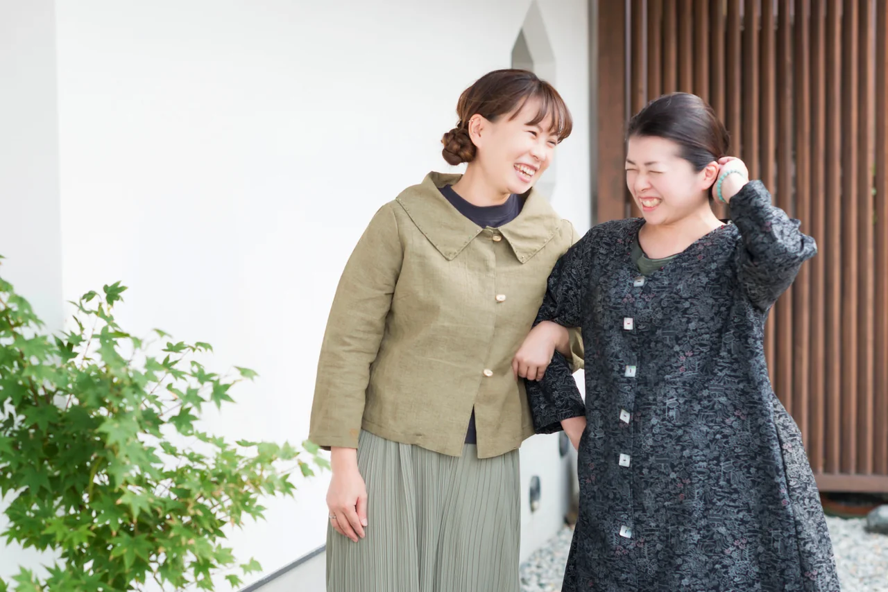 着物服を着て笑顔で寄り添う二人の女性