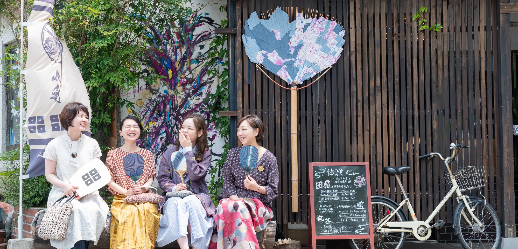 着物から生まれた洋服で、笑顔を交わす四人の女性