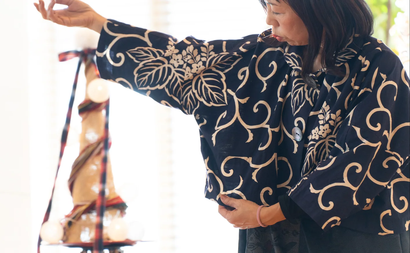 ゆったりとした紺色の着物服を試着する女性